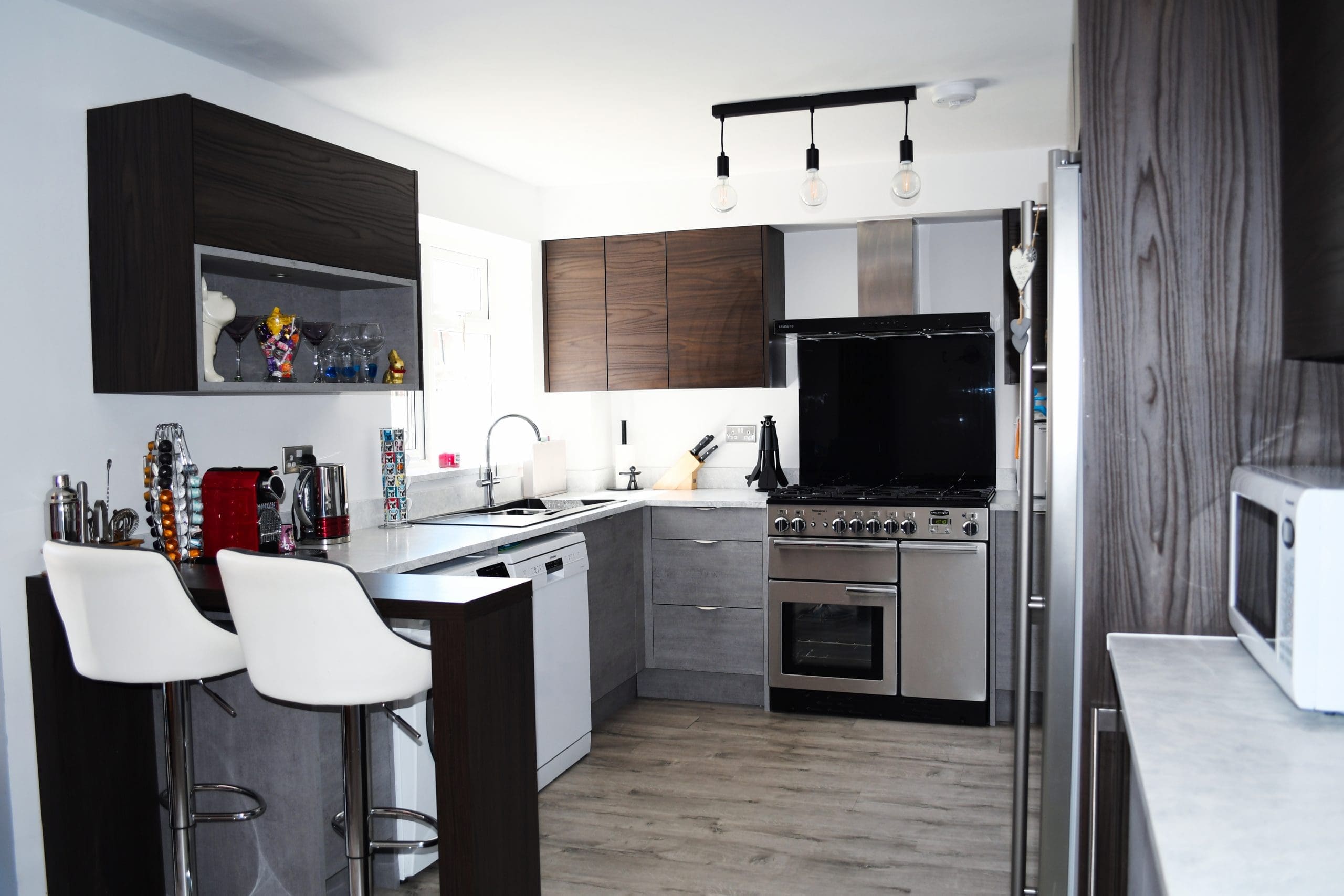 Two Tone Concrete and Dark Walnut Handle-less and Slab Kitchen, and Minerva Solid Surface Worktops and Dark Walnut chunky breakfast bar Stonemill Kitchens