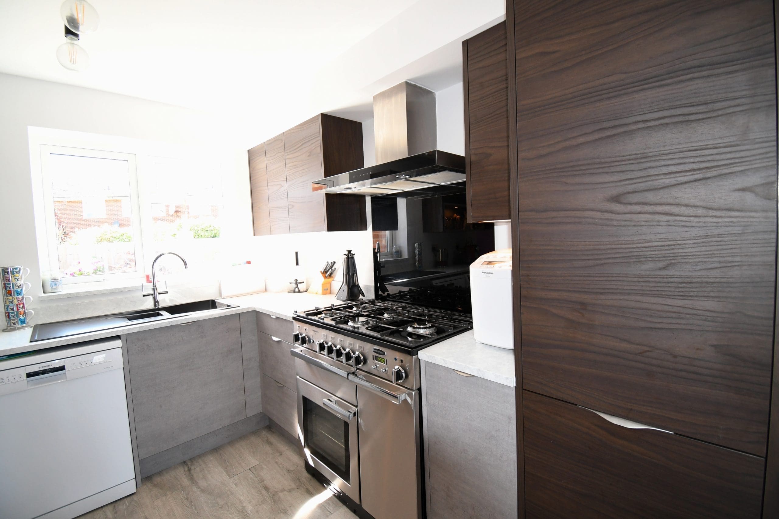 Two Tone Concrete and Dark Walnut Handle-less and Slab Kitchen, and Minerva Solid Surface Worktops Stonemill Kitchens
