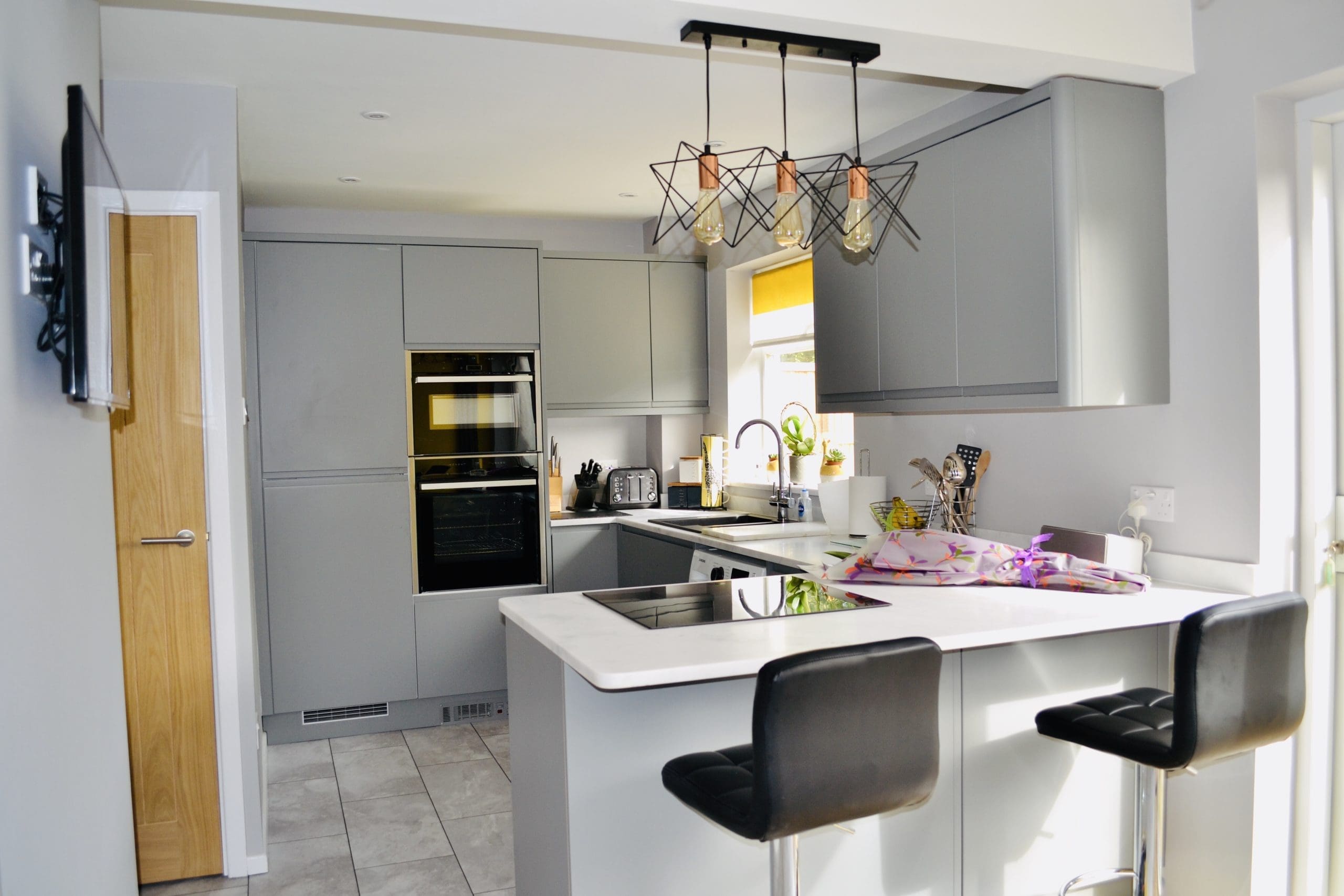 Dust Grey J handle Kitchen With hanging pendant lights