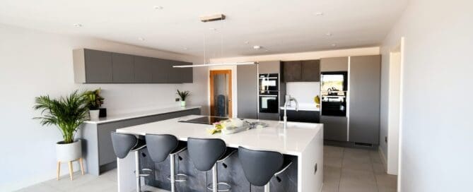 Black Marble and Light Grey True Handleless Kitchen with Stainless Steel Rails and Quartz Worktop Stonemill Kitchens