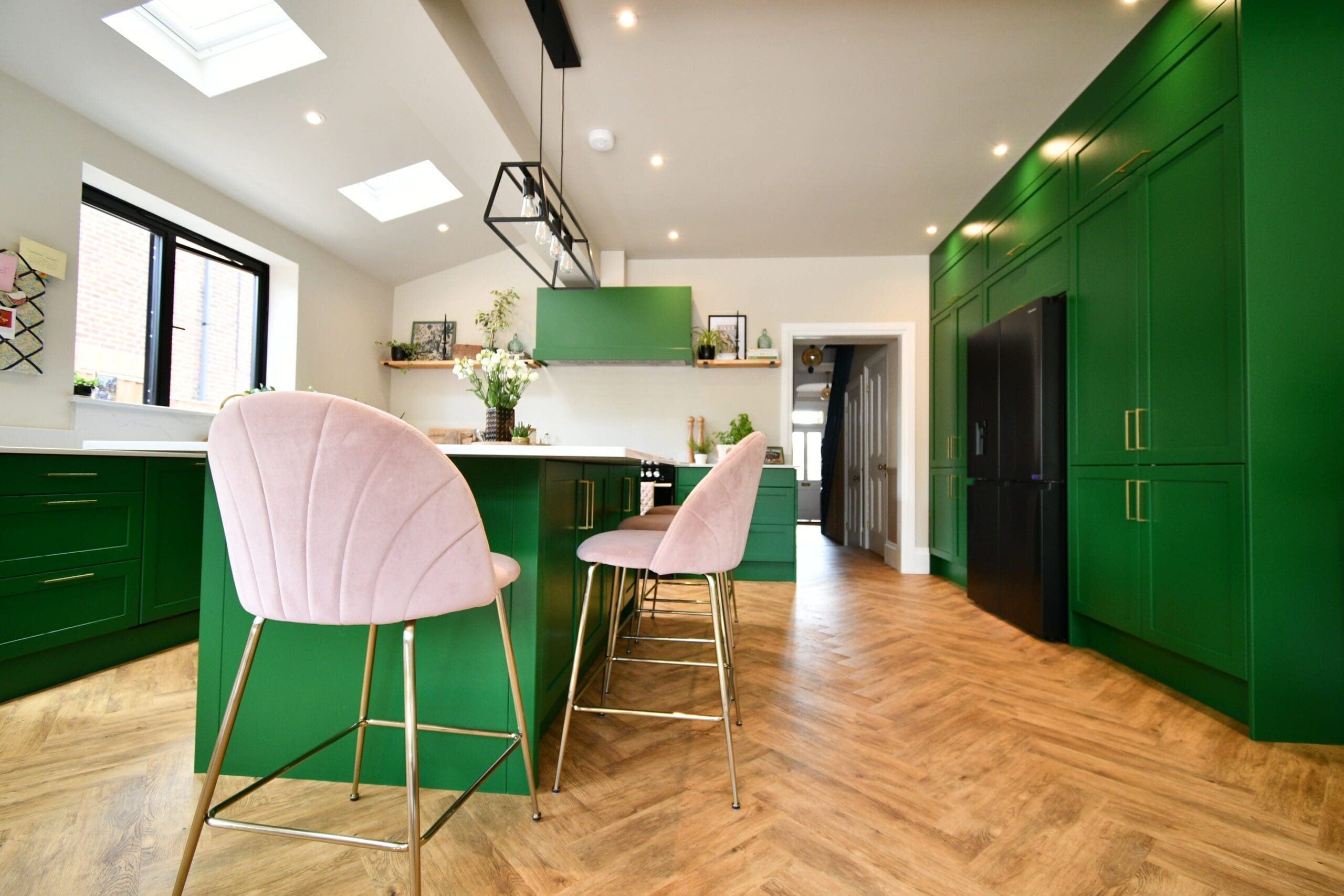Classic kitchen design with green shaker cabinets, white quartz surfaces, and a wine cooler