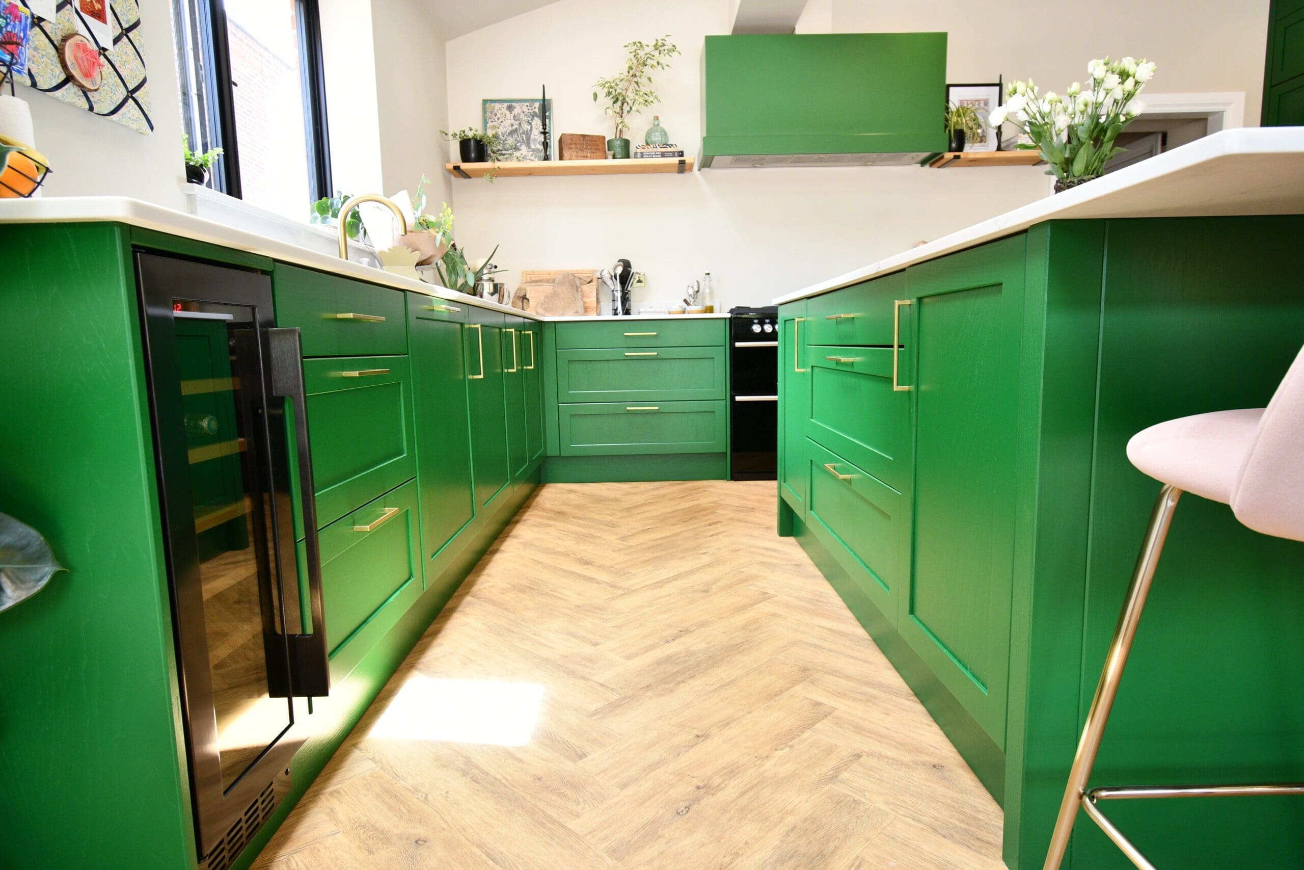 Green shaker kitchen with white quartz countertops and brass handles Stylish green shaker kitchen with white quartz counters and built-in wine cooler
